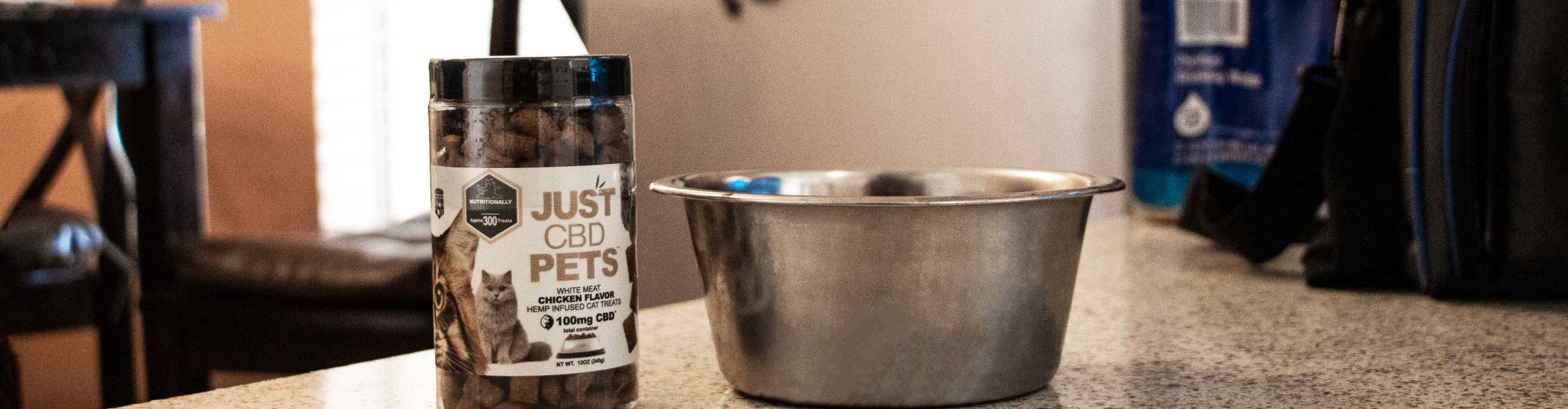 Just CBD for Pets standing on top of kitchen table with dog bowl