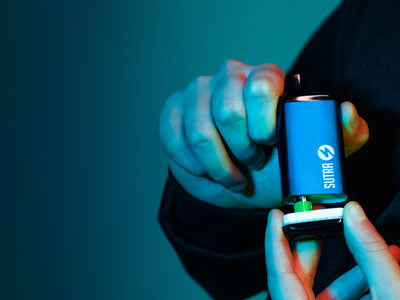 Man holding Sutra SILO Pro in front of blue studio background
