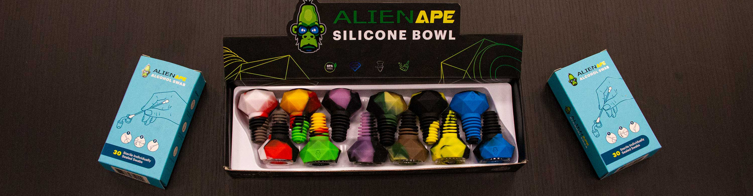 Alien Ape products display laying down on black wooden table.