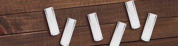 Aromed glass mouthpieces laying on wooden table.