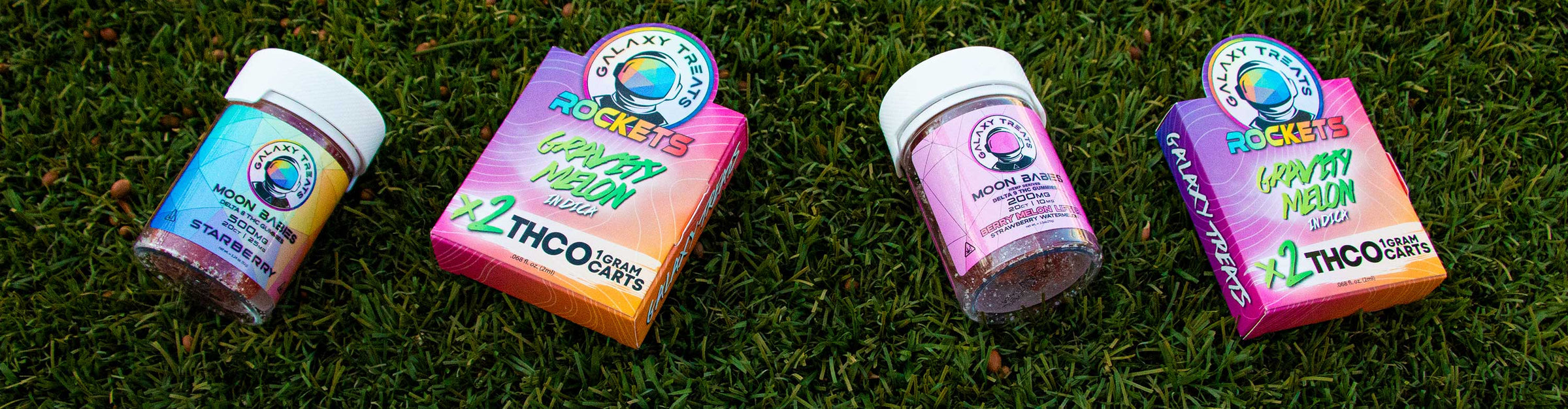 Galaxy Treats products laying down on grass outside near office building.