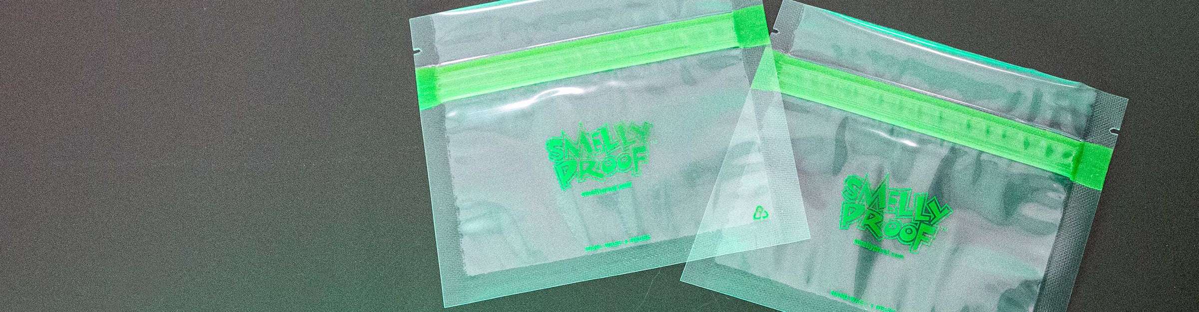 Smelly Proof Bags laying down on black table with green lighting.