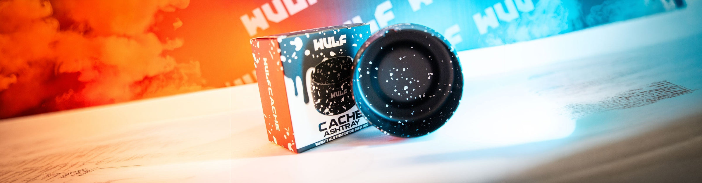 Wulf Ashtray on surface with colorful orange and blue lighting and smoke
