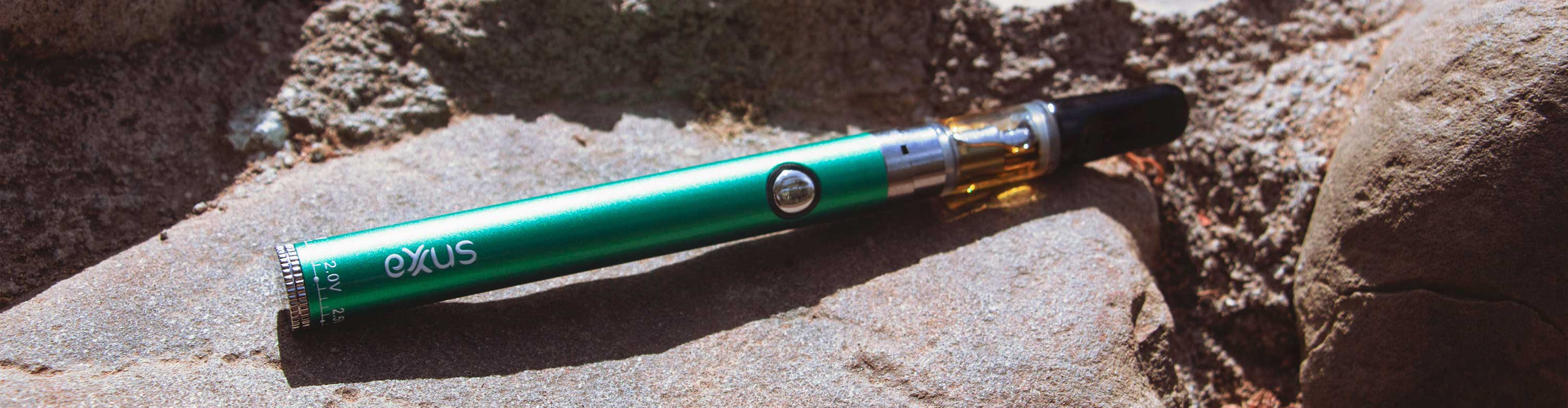 Exxus Twistr Cartridge Vaporizer laying down on rocks at park