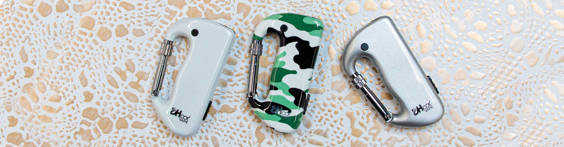 DHook Vape Vaporizers laying down on gold and white textured background