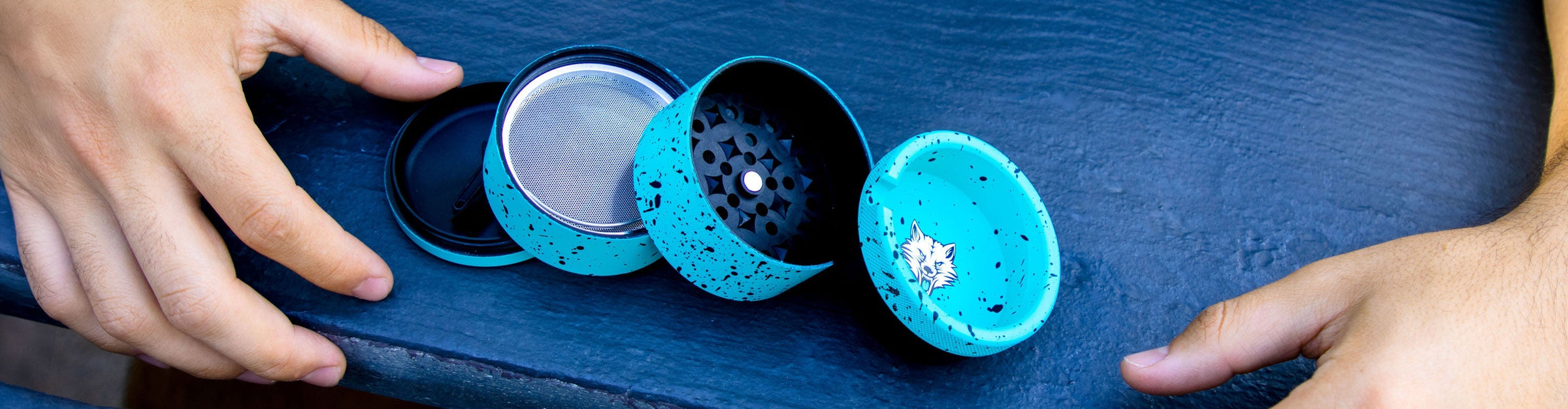 Man holding apart Sutra Grinder inside studio with purple and magenta lighting