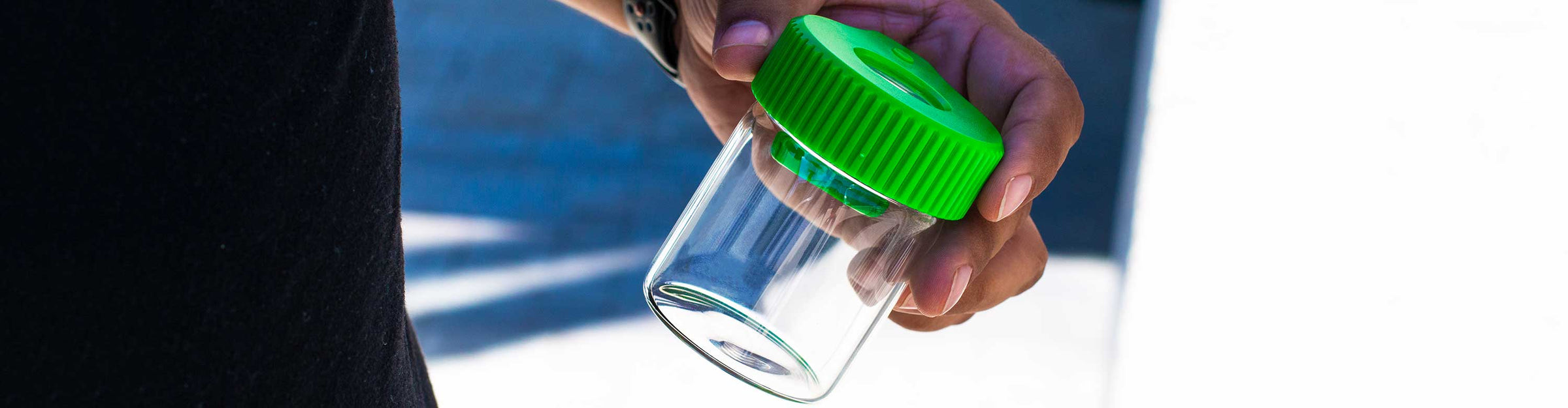 man holding the Sticker Cartel Mag Jar Magnetic Storage Jar with LED Light outside near building