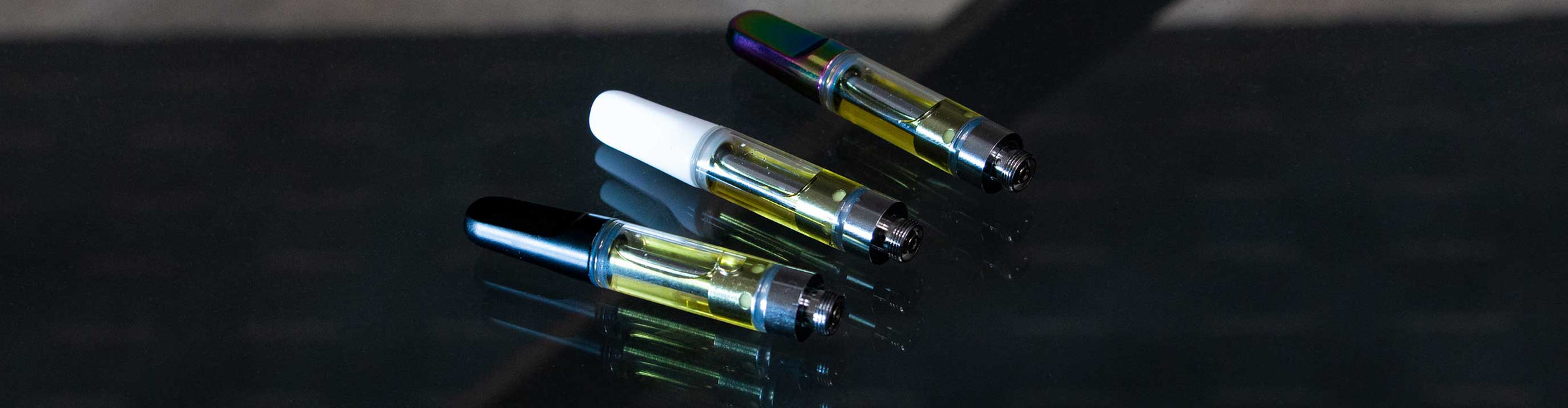 Cartridge Vaporizers laying down on glass table inside office.