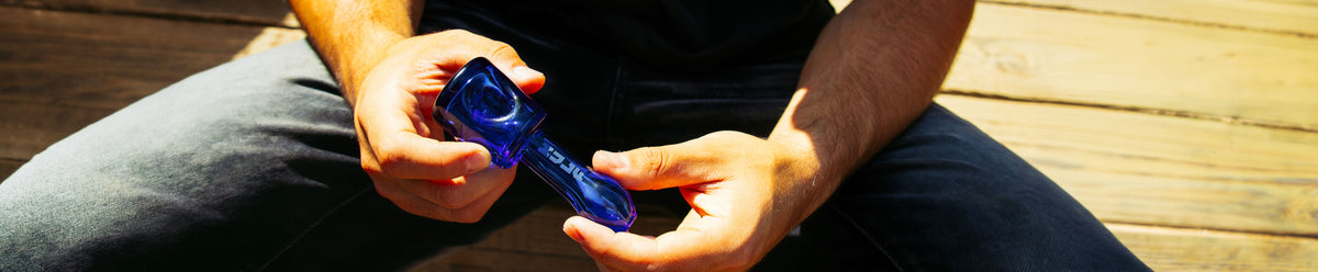 man holding WULF Mods bell pipe on a lifestyle background with wood texture