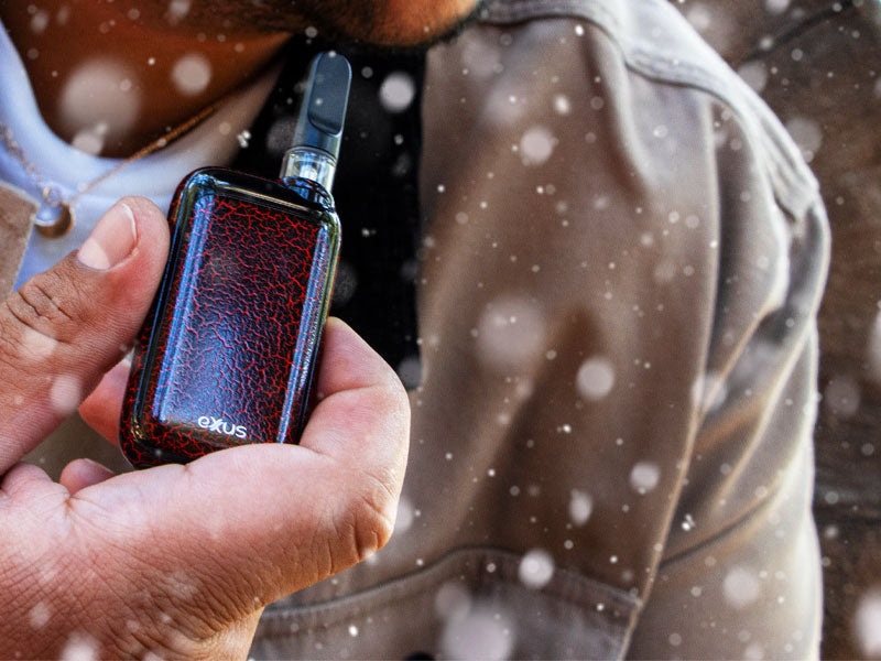 Man holding Exxus Rizo Black Red Crackle in front of tree with snow falling