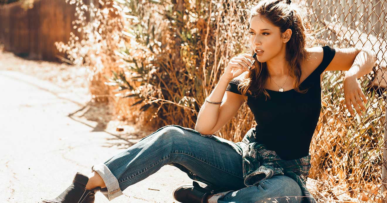 Woman sitting on ground holding Mini Plus