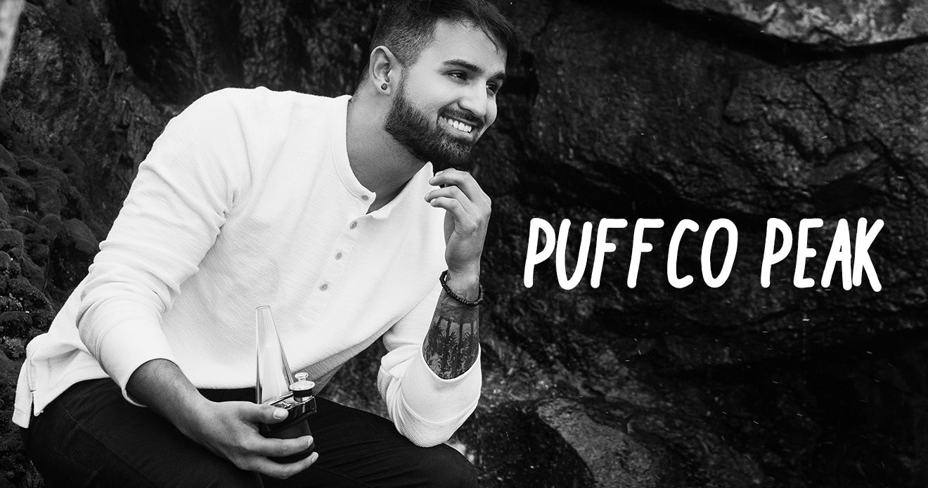 Man holding Puffco Peak against a rock wall
