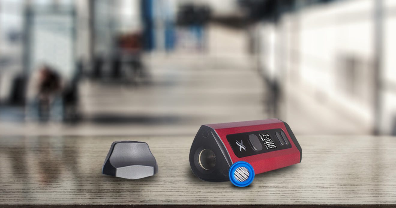 Exxus Mini Plus laying on table inside home with mouthpiece and screen assembly