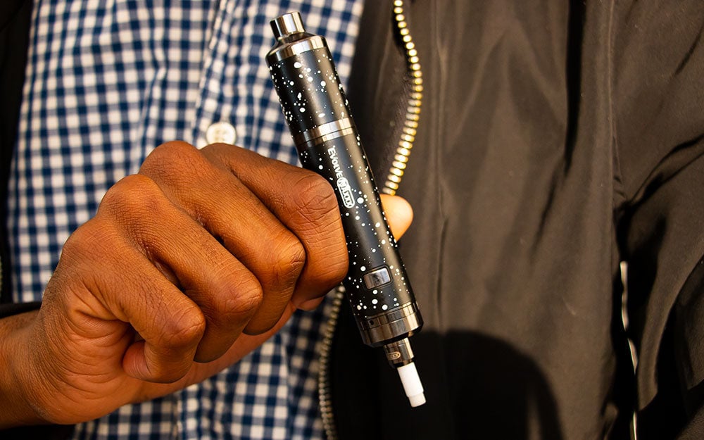 Man holding Black with White Spatter Wulf Evolve Maxxx nectar collector mode outside