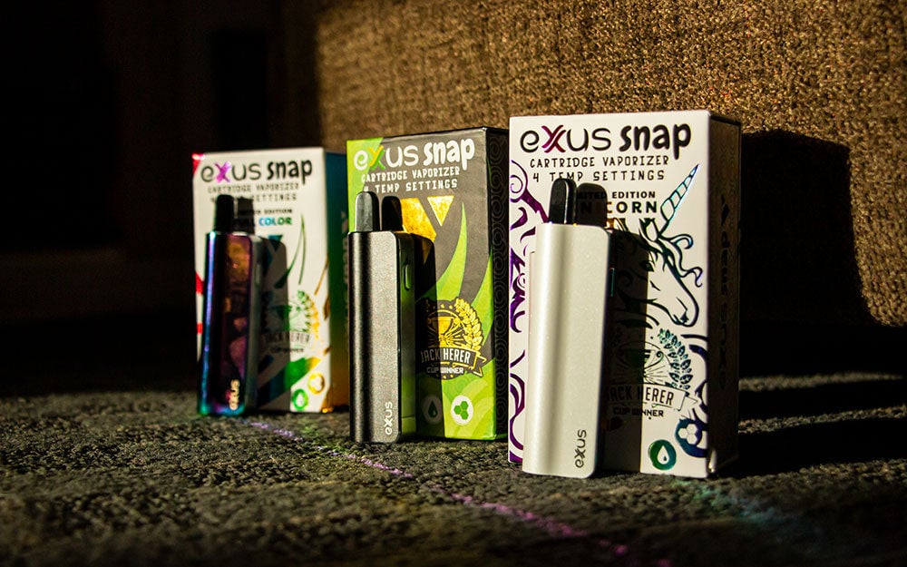 3 Exxus Snap VVs standing on carpet floor with boxes under cool lighting