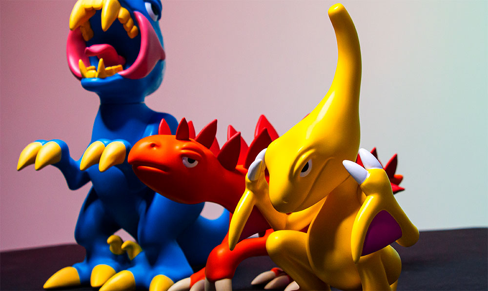 Elbo Glass dinosaur vinyl figures in blue, yellow and red