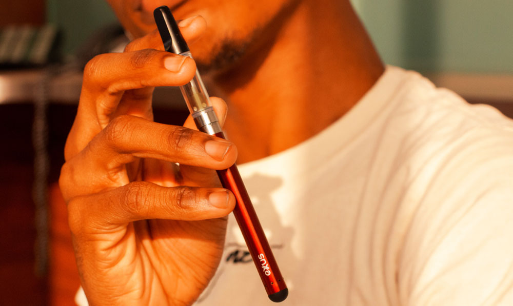 Exxus Slim Auto Draw in man's hands in front of office desk
