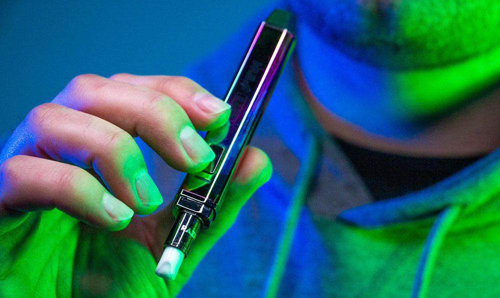 Wulf Mods RAZR in man's hand with blue and green studio lighting