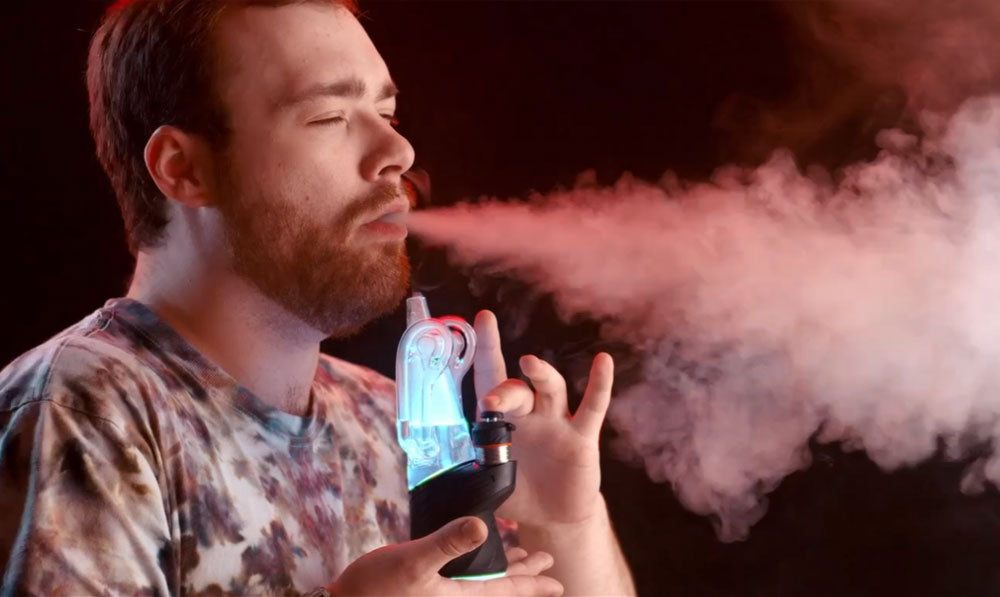 man blowing smoke using the peak pro with 3d xl chamber