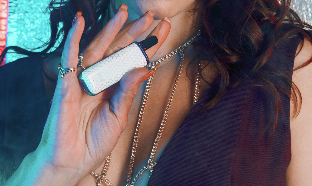 Woman holding Exxus Minovo in front of blue teal studio background
