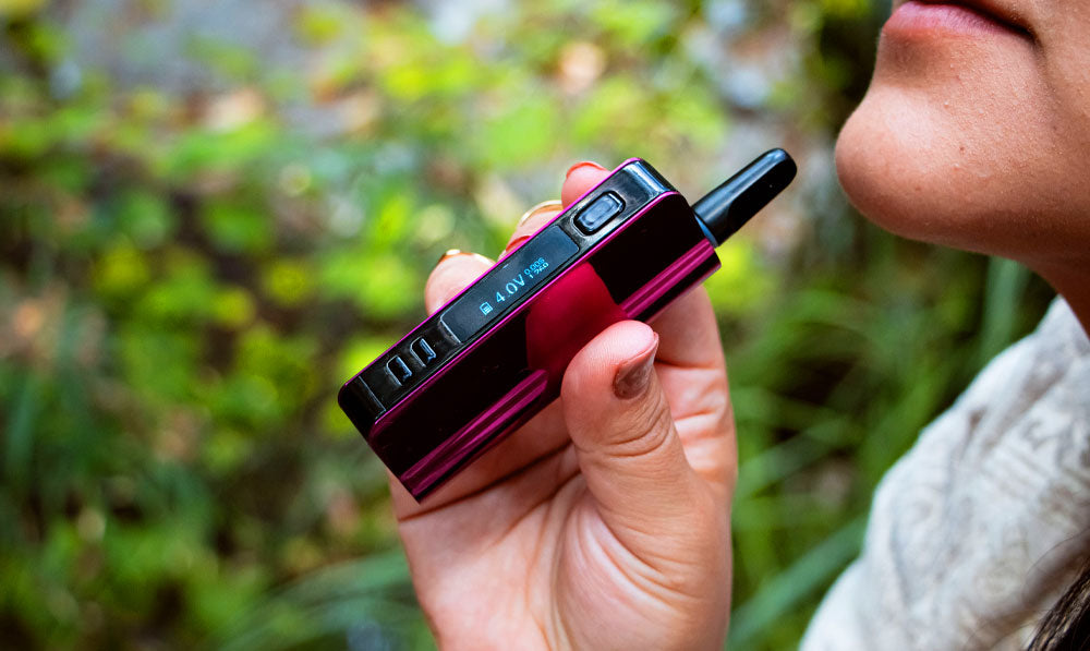 Woman holding Exxus Snap VV Pro in front of forest trail
