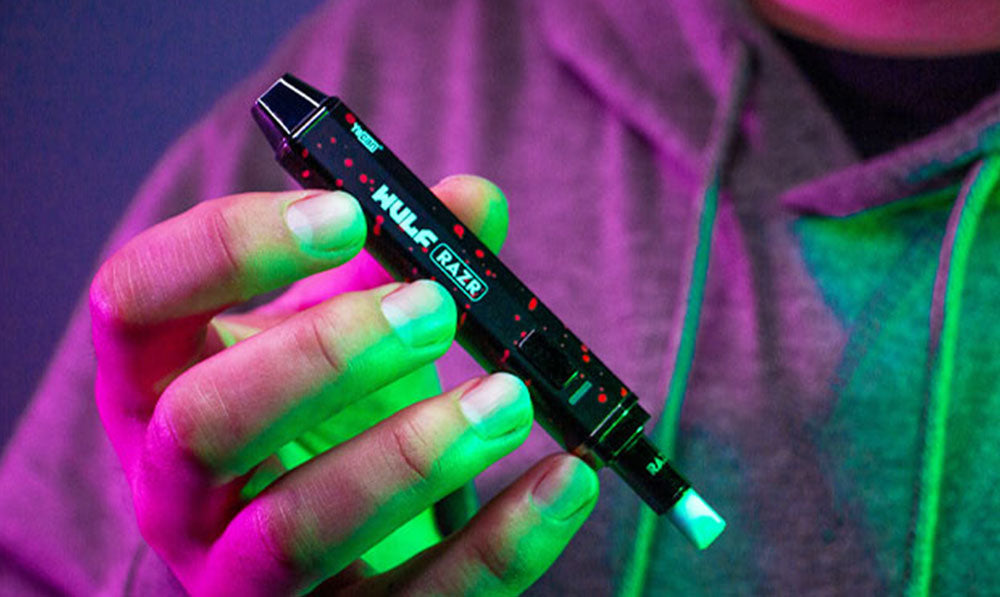 man holding Wulf Razr black red spatter inside studio
