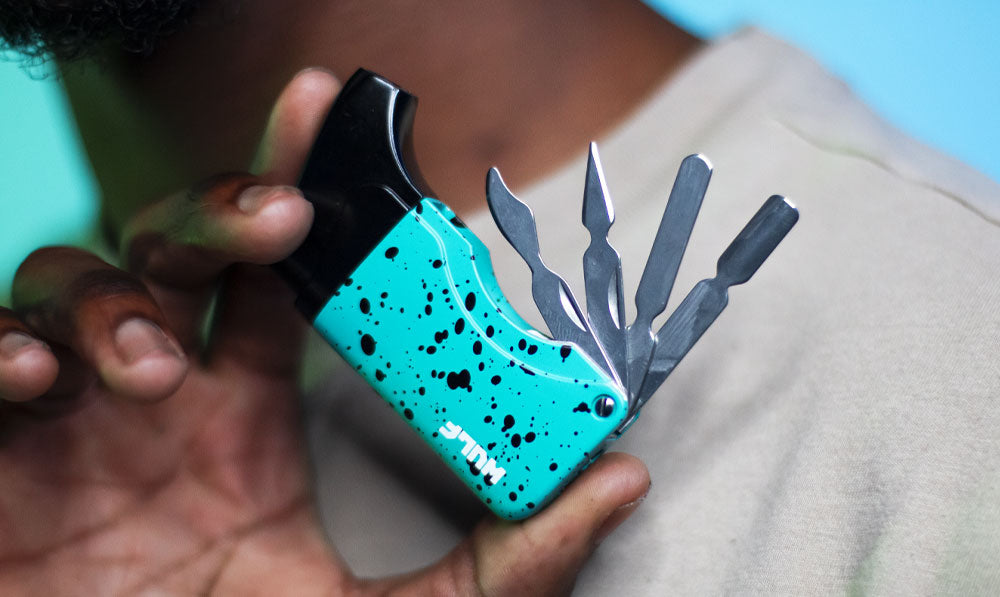 Man holding Wulf Omni Multi Dab tool torch in front of blue studio background