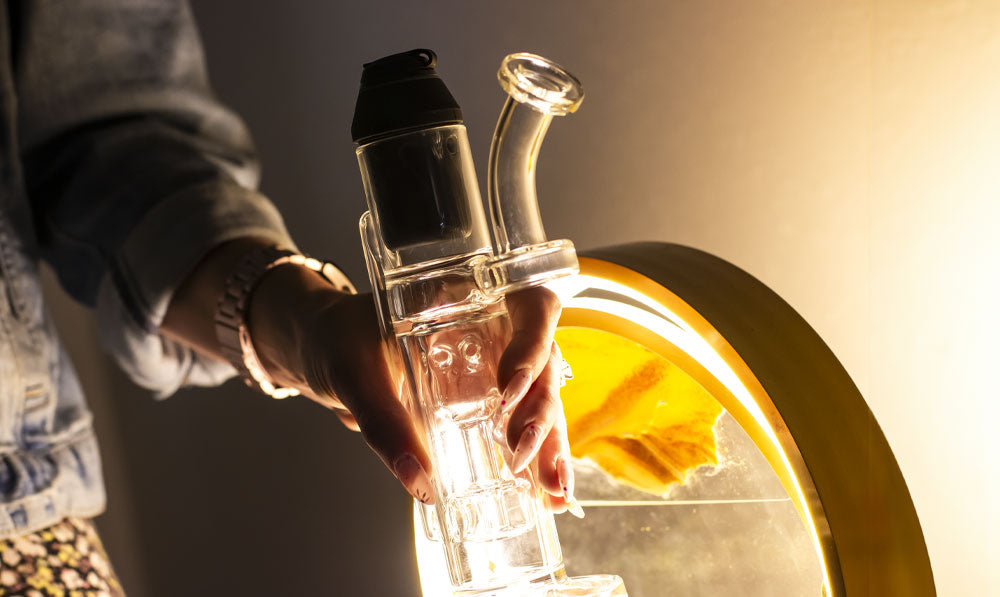 Woman holding Proxy 9 Inch Recycler in front of warm lighting
