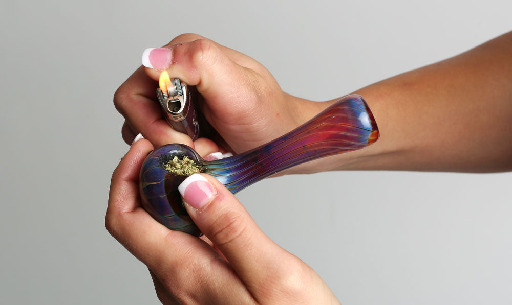 Woman sparking glass bowl in front of grey background