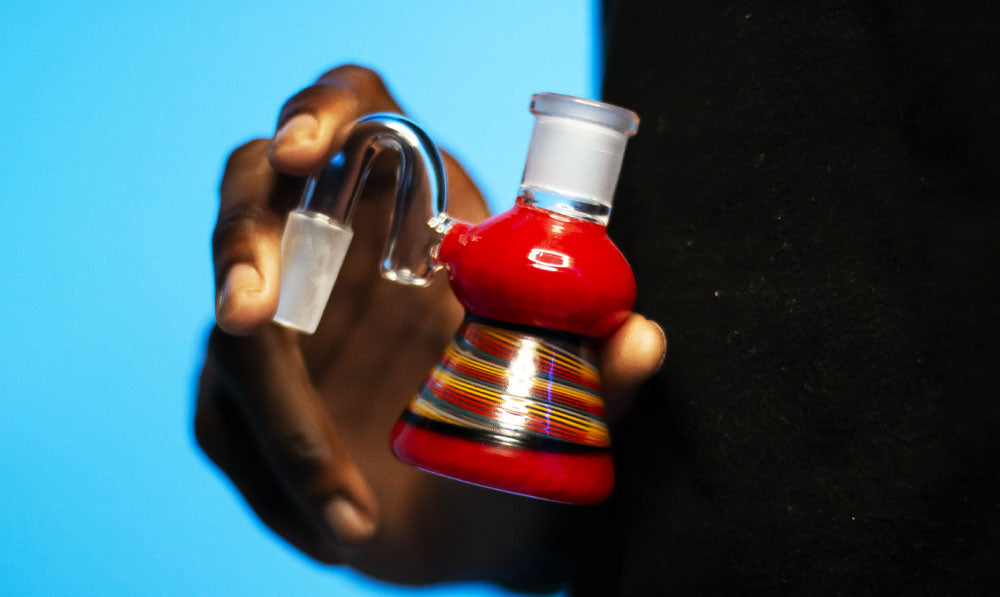 Man holding Ash Catcher in front of blue studio background