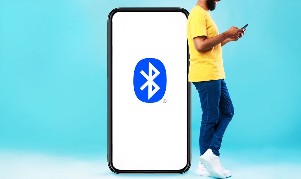 Man standing near phone with Bluetooth icon on surface