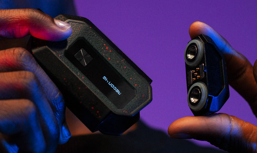Man holding Wulf Mods Recon 4G apart in front of purple studio background