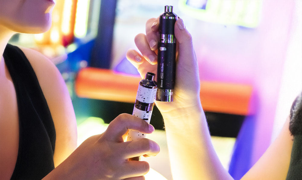 Two women holding Wulf Evolve Plus XL Duo at arcade