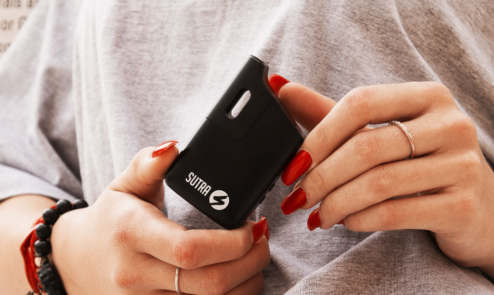 Woman with red nails holding Sutra Mini