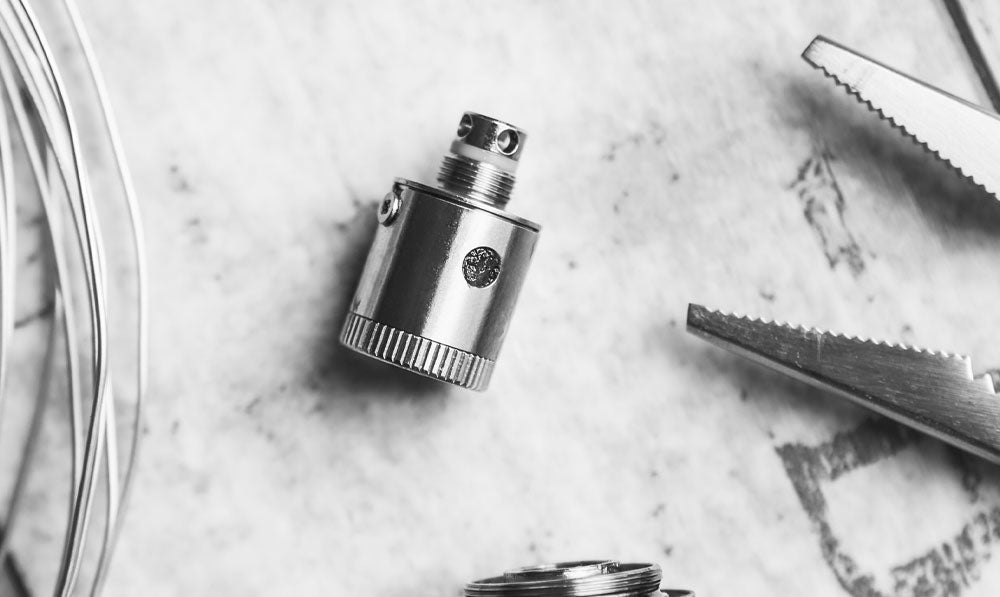 Atomizer resting on a marble surface beside tools