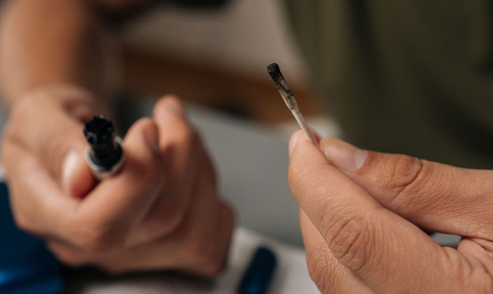 Close up of a person cleaning an atomizer with a cotton swab