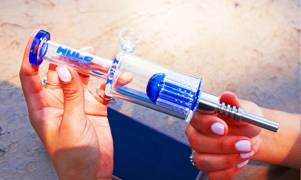 Person holding a WULF Timber nectar collector over a park table