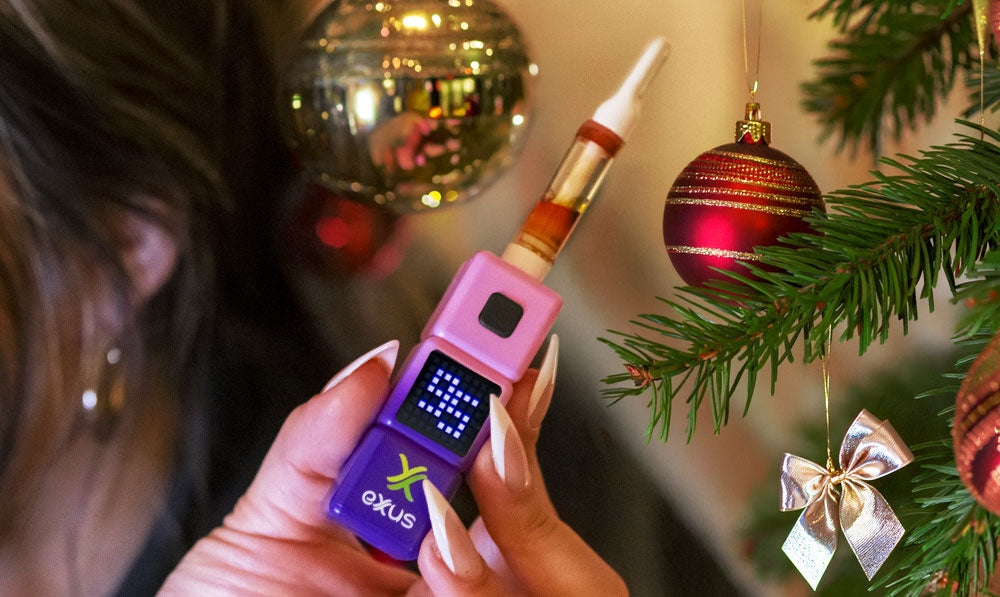 Woman holding Exxus Stax near Christmas tree
