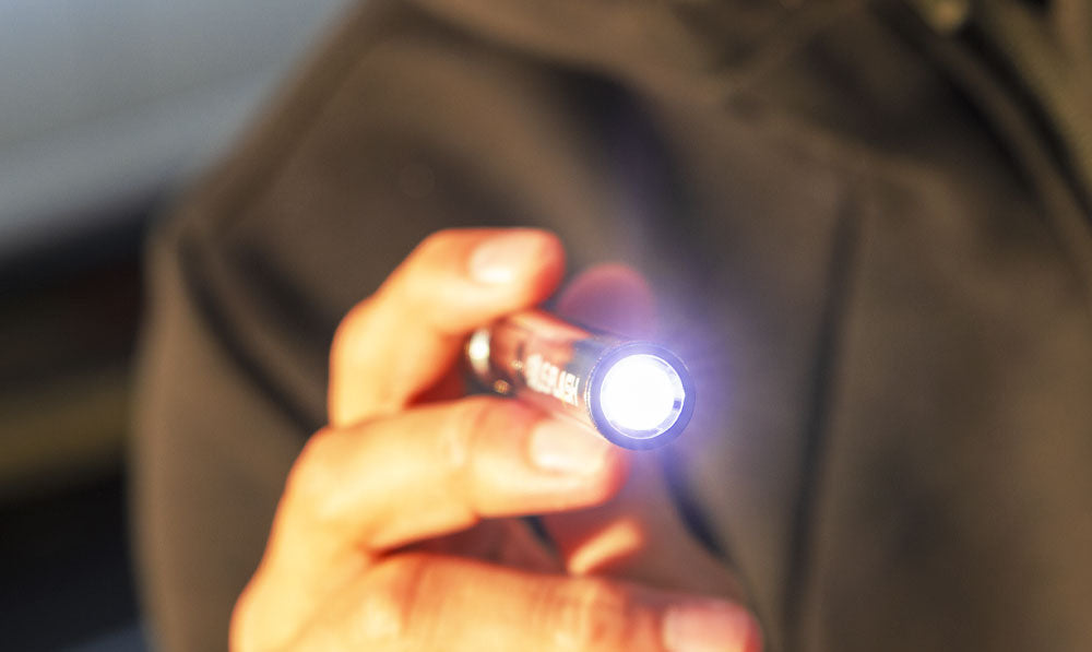 Person pointing Exxus Flash with flashlight on