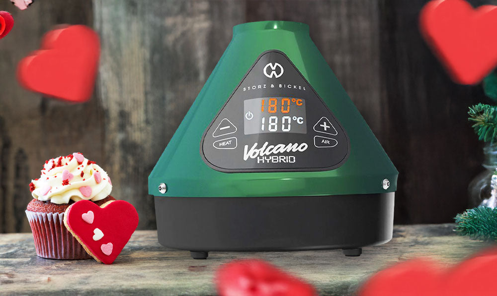 Storz & Bickel Evergreen Hybrid Volcano on dark surface with cupcakes and hearts falling