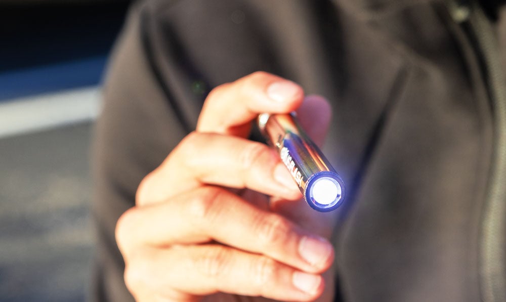 Man holding Exxus Flash with flashlight on