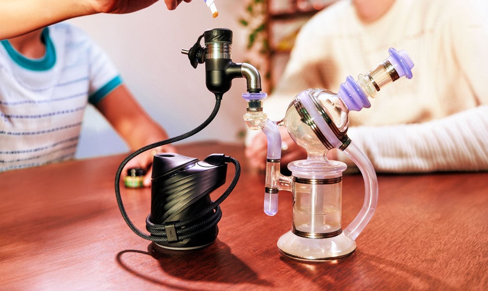 Two people using Puffco Peak Pro Link on wooden surface