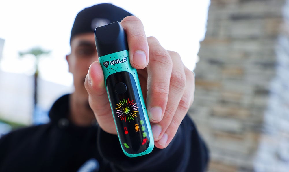 man showing off the Wulf Budr Wax Vaporizer outside