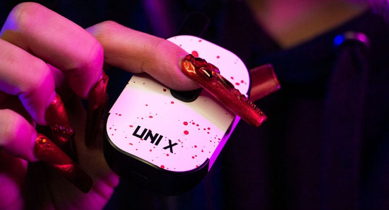 Person holding a teal Exxus VRS concentrate vaporizer