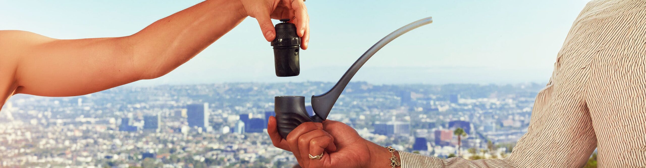Hand holding a Puffco Proxy Core with a cityscape in the background