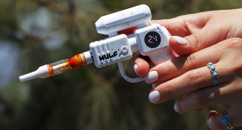Two hands holding a white WULF Zapp 510 thread battery shaped like a ray gun