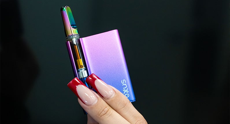 Woman holding Exxus Palm Pro with black door in background