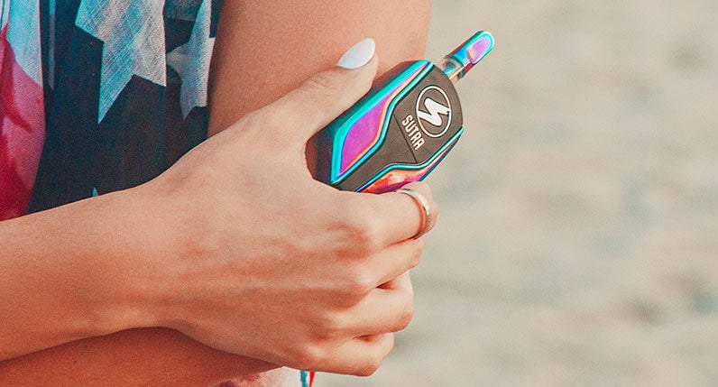 Woman with flag shirt at beach holding the Sutra Squeeze