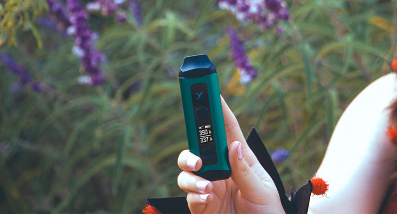 Woman in costume holding green Exxus Mini Plus at park