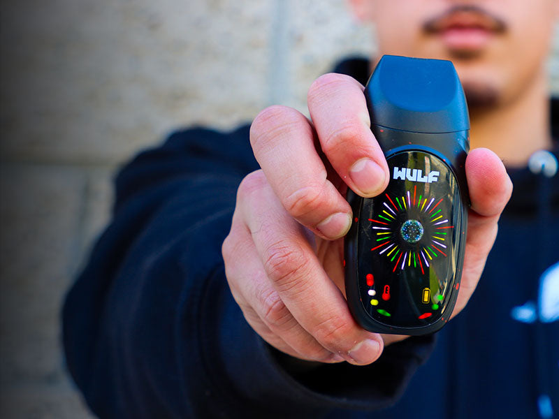 Person holding a WULF vaping device with colorful display